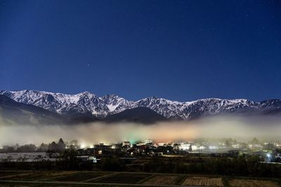 Snowcapped mountains against blue sky at night