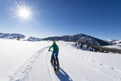 A woman riding her fat bike on a beautiful winter day in sun valley.