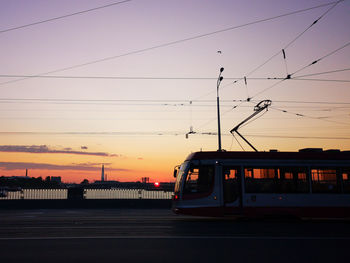 Train on railroad tracks against sky during sunset