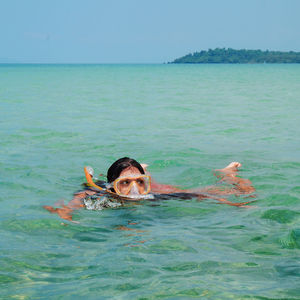 Mid adult woman snorkeling in sea