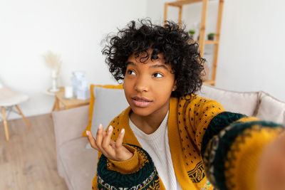 Portrait of smiling young woman sitting at home