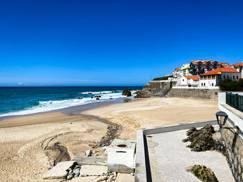 Scenic view of beach against clear blue sky