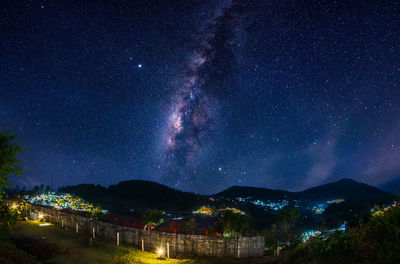 Scenic view of illuminated mountains against sky at night