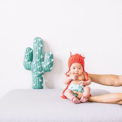 Cropped hands of father holding toddler on bed