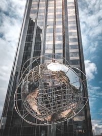 Low angle view of modern glass building against sky