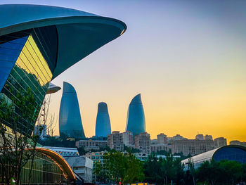 Modern buildings against sky during sunset