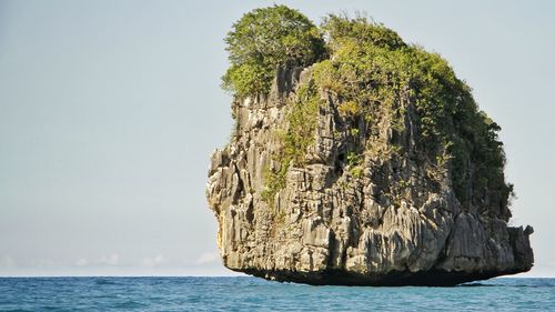 Rock formation in sea against sky