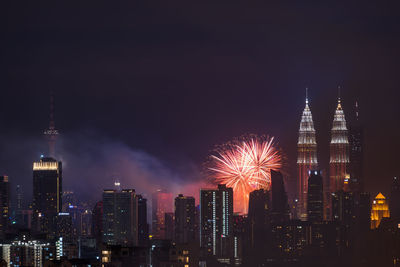 Firework display over city lit up at night