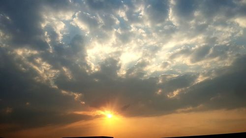 Low angle view of storm clouds at sunset