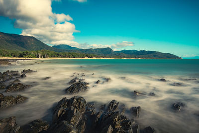 Scenic view of rocky shore and sea against sky 