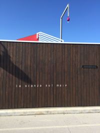 Red flag against building against clear blue sky