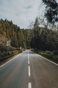 Road amidst trees against sky