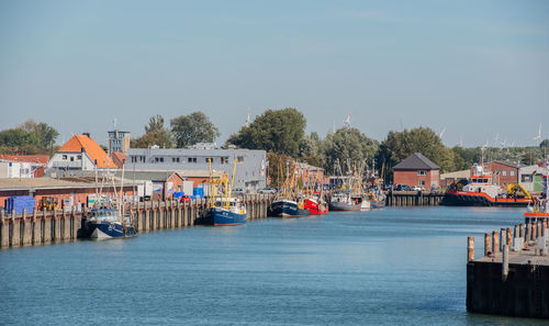 Scenic view of river by buildings against clear sky