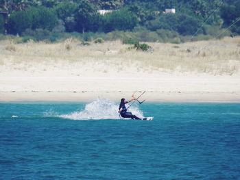 Full length of man kiteboarding on sea