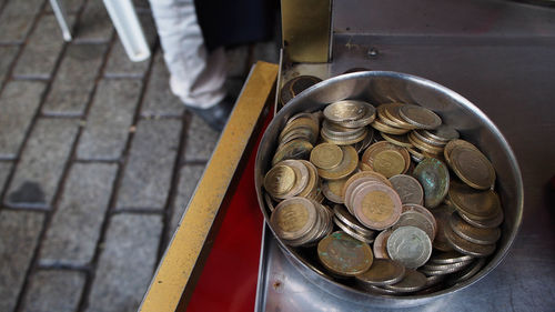 High angle view of coins in bowl on table