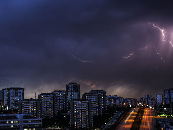 Aerial view of illuminated cityscape against sky at night