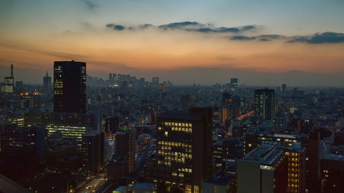 Aerial view of city lit up at sunset