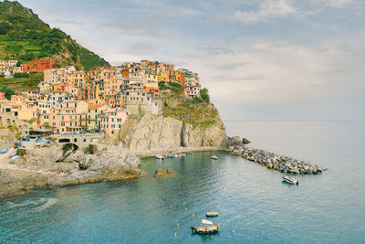 Scenic view of sea by buildings against sky