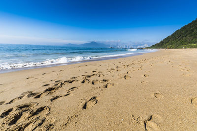 Scenic view of beach against blue sky