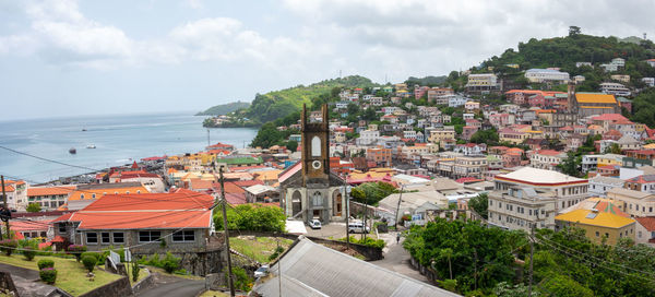 High angle view of townscape by sea against sky