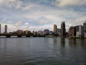 River by buildings against sky in city