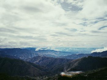 Scenic view of mountains against cloudy sky