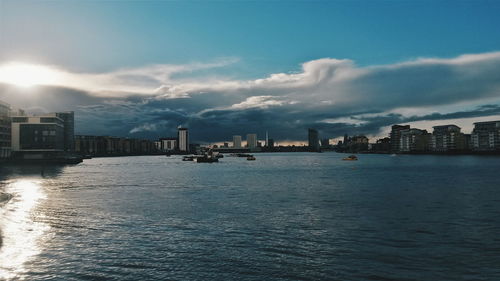 River in city against cloudy sky