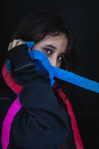 Portrait of young woman paper decoration against black background