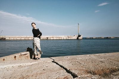 Full length of woman standing at promenade against sky