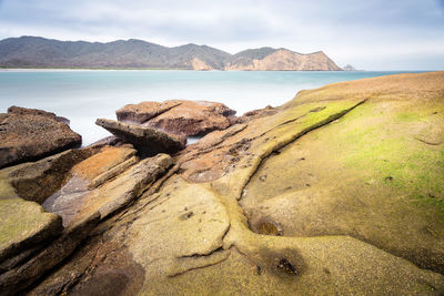 Scenic view of sea and mountains against sky