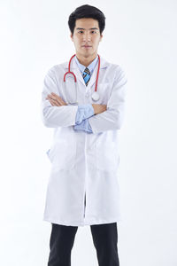 Portrait of young man standing against white background