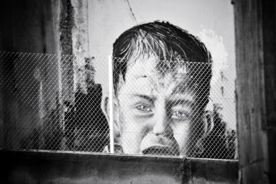 Portrait of woman looking through window