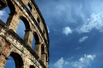 Low angle view of coliseum against sky