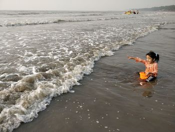 People enjoying at beach against sky