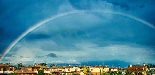 Rainbow over town against sky