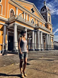 Full length of woman standing against sky in city