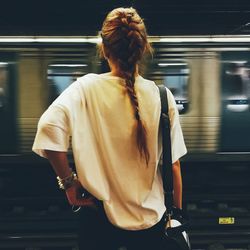 Rear view of woman standing at subway station