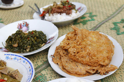 Straw mat with indonesia traditional dishes and focus on crispy deep-fried eggs at yogyakarta