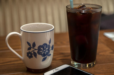 Close-up of drinks and mobile phone on table