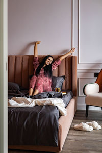 Happy woman relaxing on bed at home