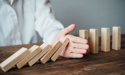 Midsection of man holding wooden blocks on table