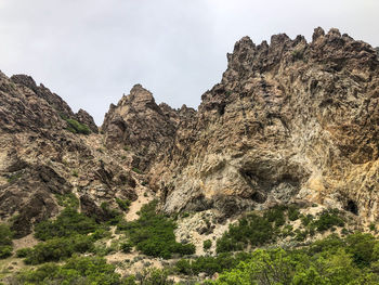 Low angle view of rocky mountains against sky