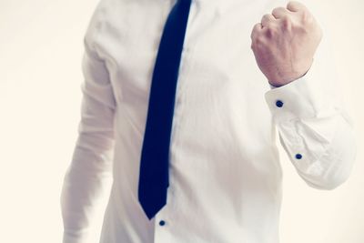 Midsection of man with arms outstretched standing against white background