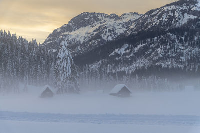 Snow covered land and mountains against sky