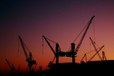 Low angle view of crane at sunset