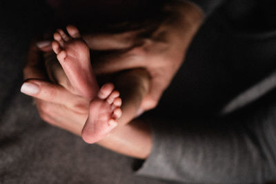 Close-up of mother holding baby legs