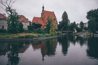 Scenic view of lake by buildings against sky