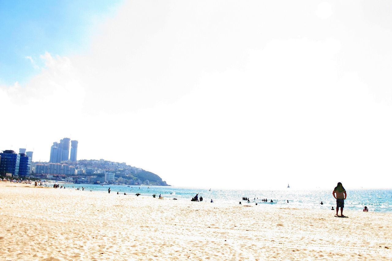 beach, sea, sand, shore, water, leisure activity, lifestyles, horizon over water, vacations, copy space, person, sky, clear sky, large group of people, men, tourist, coastline, built structure, summer