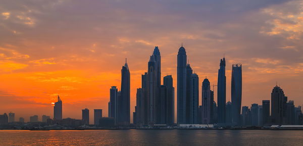 View of modern buildings against sky during sunset