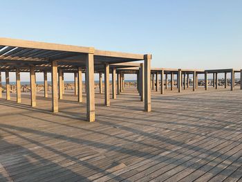 Wooden posts on beach against clear sky